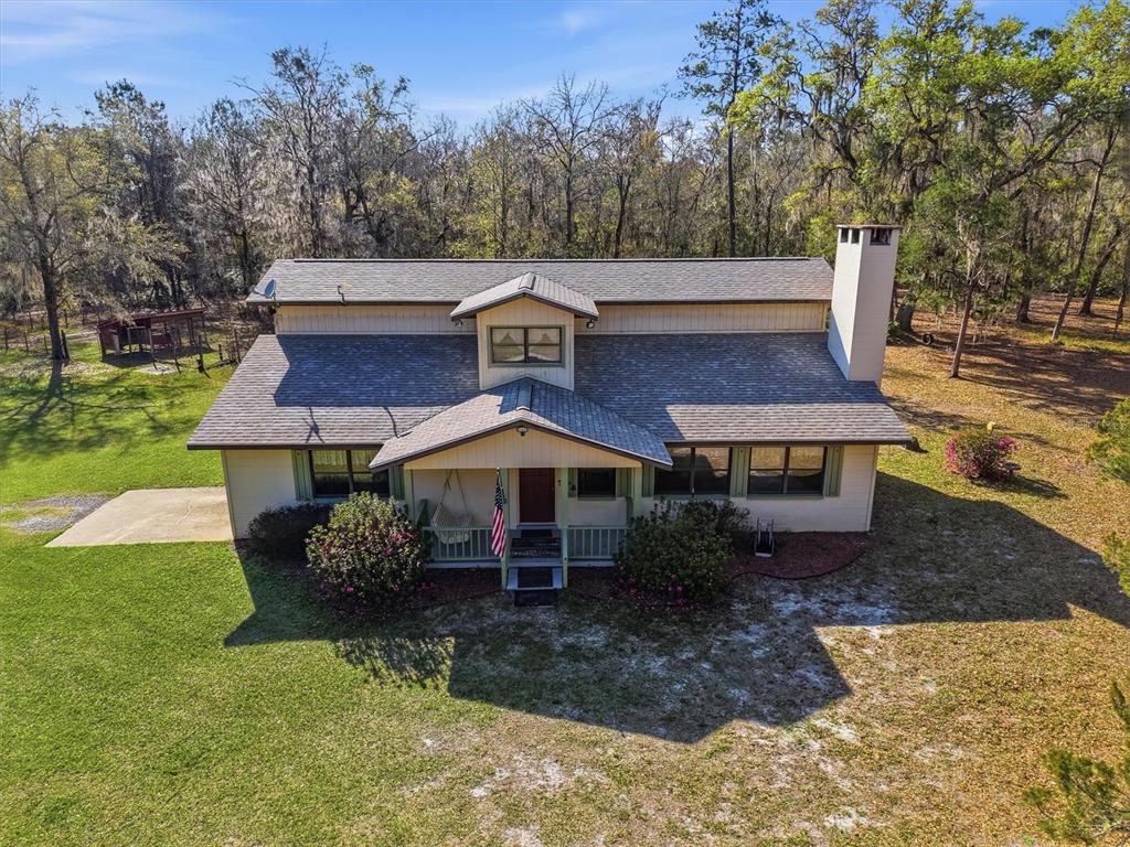 An aerial view of a two-story house with a porch, chimney, and surrounding wooded yard — 14600 NW 216TH PLACE, MICANOPY, FL