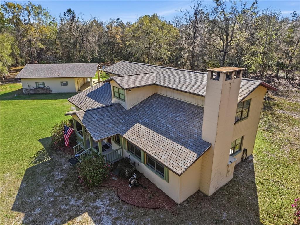 An elevated exterior view of a two-story house with a chimney and a detached garage — 14600 NW 216TH PLACE, MICANOPY, FL