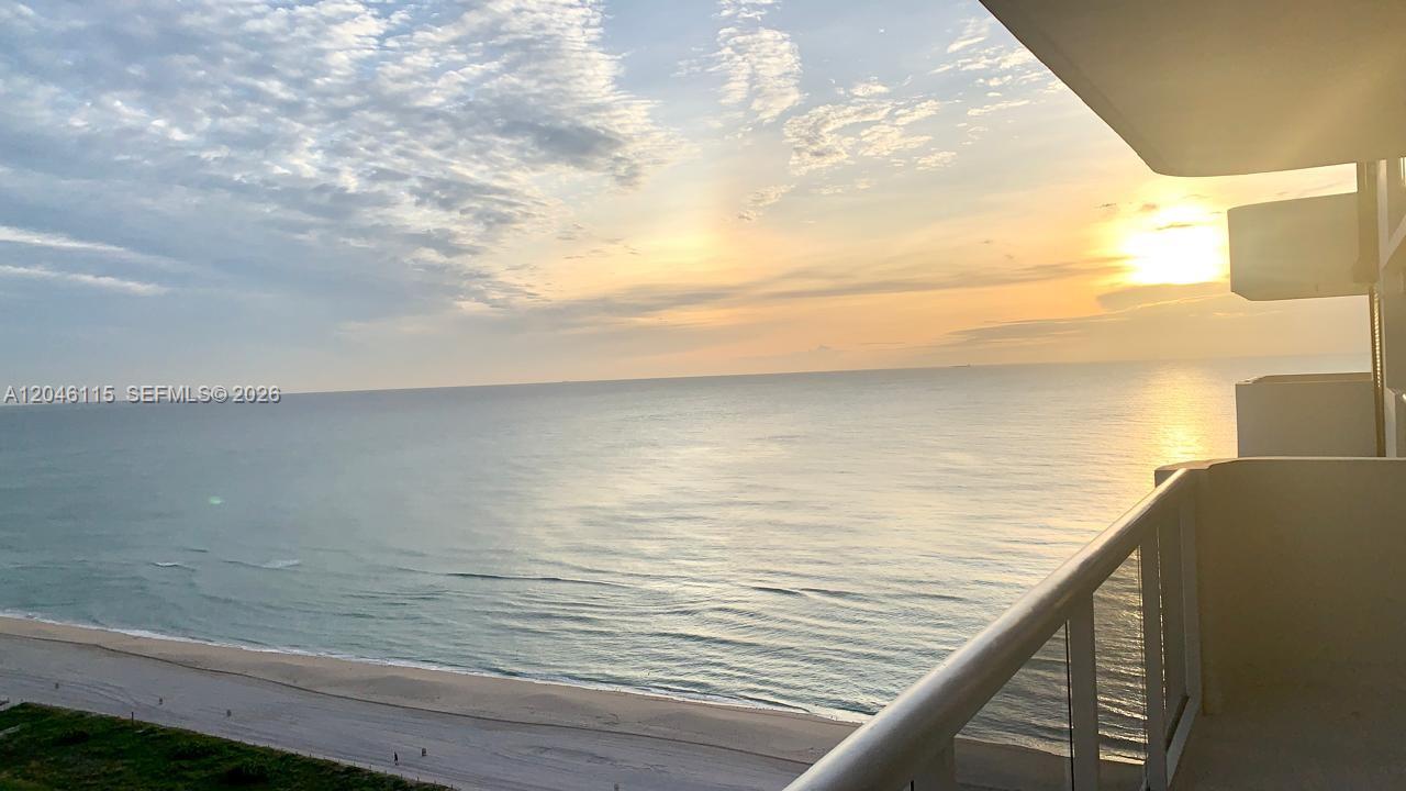 A high-angle view of a sandy beach and ocean from a balcony at sunrise — 5757 Collins Ave # 2207, Miami Beach FL 33140, MIAMI BEACH, FL