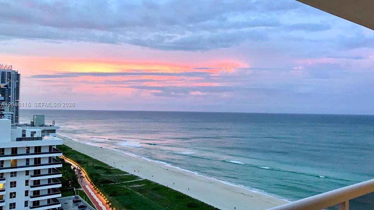 An elevated view of a beach, ocean, and coastal buildings at sunset — 5757 Collins Ave # 2207, Miami Beach FL 33140, MIAMI BEACH, FL