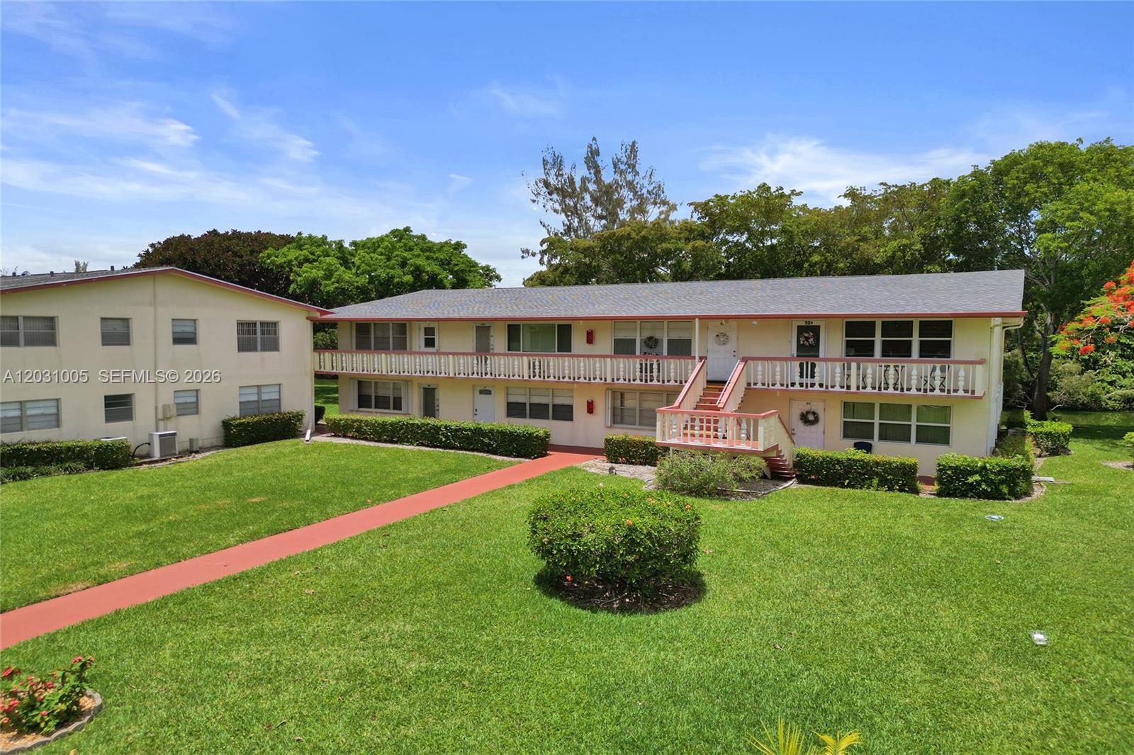 A two-story apartment building features a red walkway, a balcony, and a grassy lawn — 47 Camden # B, West Palm Beach FL 33417, WEST PALM BEACH, FL