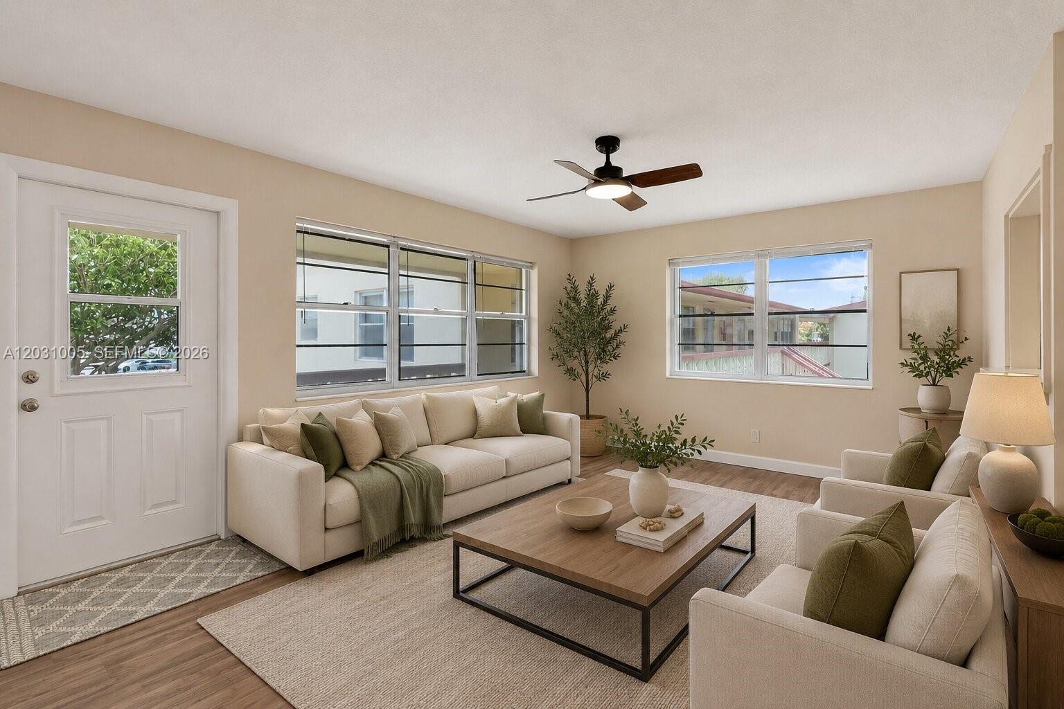 This living room features a beige sofa, two armchairs, a coffee table, and large windows — 47 Camden # B, West Palm Beach FL 33417, WEST PALM BEACH, FL