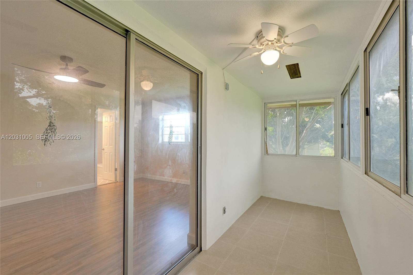 A sunroom with tile flooring, a ceiling fan, and sliding glass doors to a room — 47 Camden # B, West Palm Beach FL 33417, WEST PALM BEACH, FL