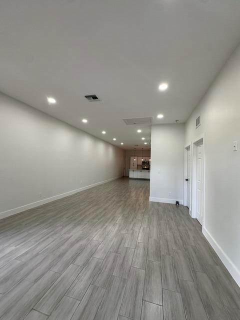 An open-concept living area features light wood-look tile flooring and recessed ceiling lighting — 651 NE 60th Avenue, Okeechobee FL 34974, OKEECHOBEE, FL