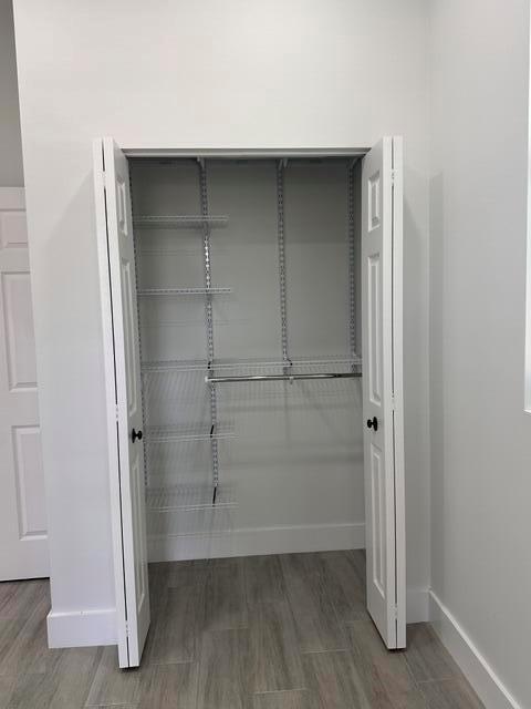 A closet with white bi-fold doors, wire shelving, and a hanging rod on a wood floor — 651 NE 60th Avenue, Okeechobee FL 34974, OKEECHOBEE, FL