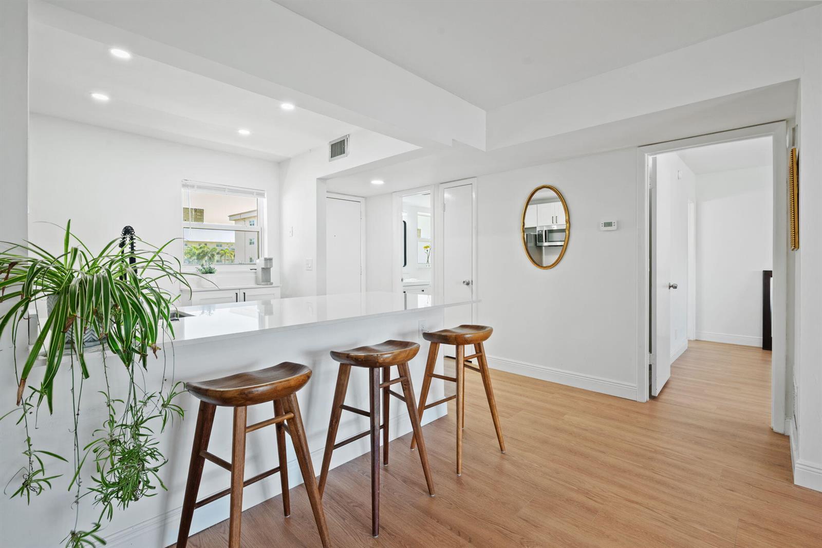 A kitchen island with a stainless steel dishwasher and sink overlooks a bright living area — 230 NE 26th Avenue # 2160, Boynton Beach FL 33435, BOYNTON BEACH, FL