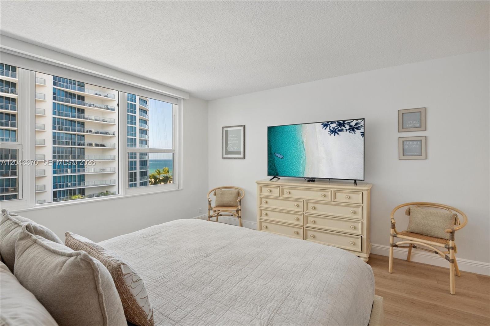 A bedroom features a bed, a dresser with a television, two chairs, and a window view — 3505 S Ocean Dr # 708, Hollywood FL 33019, HOLLYWOOD, FL