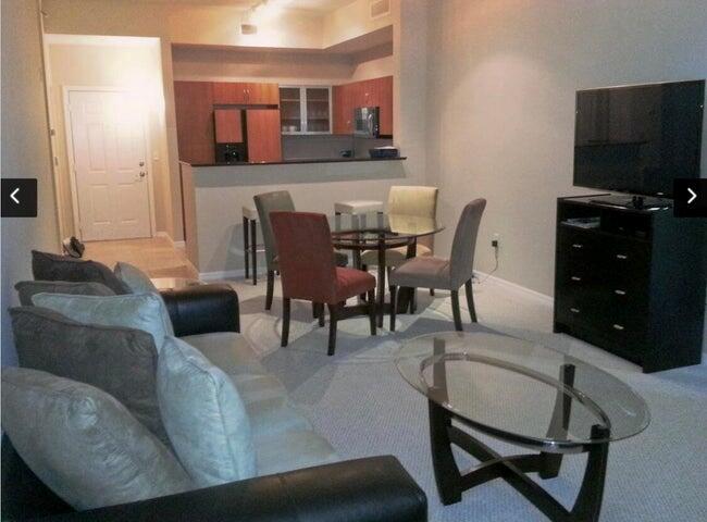 A living room with a sofa, glass coffee table, dining set, and open kitchen area — 804 E Windward Way # 119, Lantana FL 33462, LANTANA, FL
