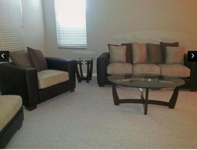 A living room features a dark brown sofa and armchair with light-colored cushions and tables — 804 E Windward Way # 119, Lantana FL 33462, LANTANA, FL