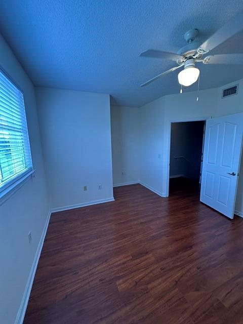 An empty room features wood-look flooring, a ceiling fan, and a white door — 2036 Alta Meadows Lane # 1403, Delray Beach FL 33444, DELRAY BEACH, FL