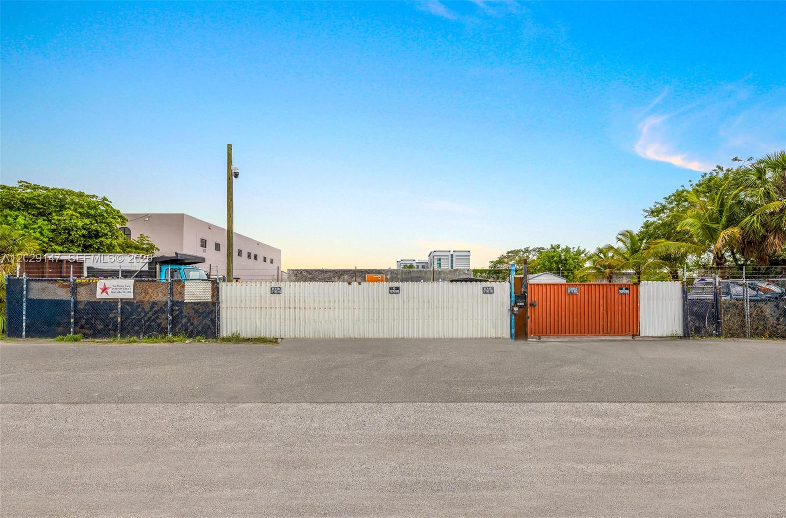 A fenced-in outdoor industrial lot with a paved foreground and a gated entrance — 14760 NW 24th Ct, Opa-Locka FL 33054, OPA-LOCKA, FL