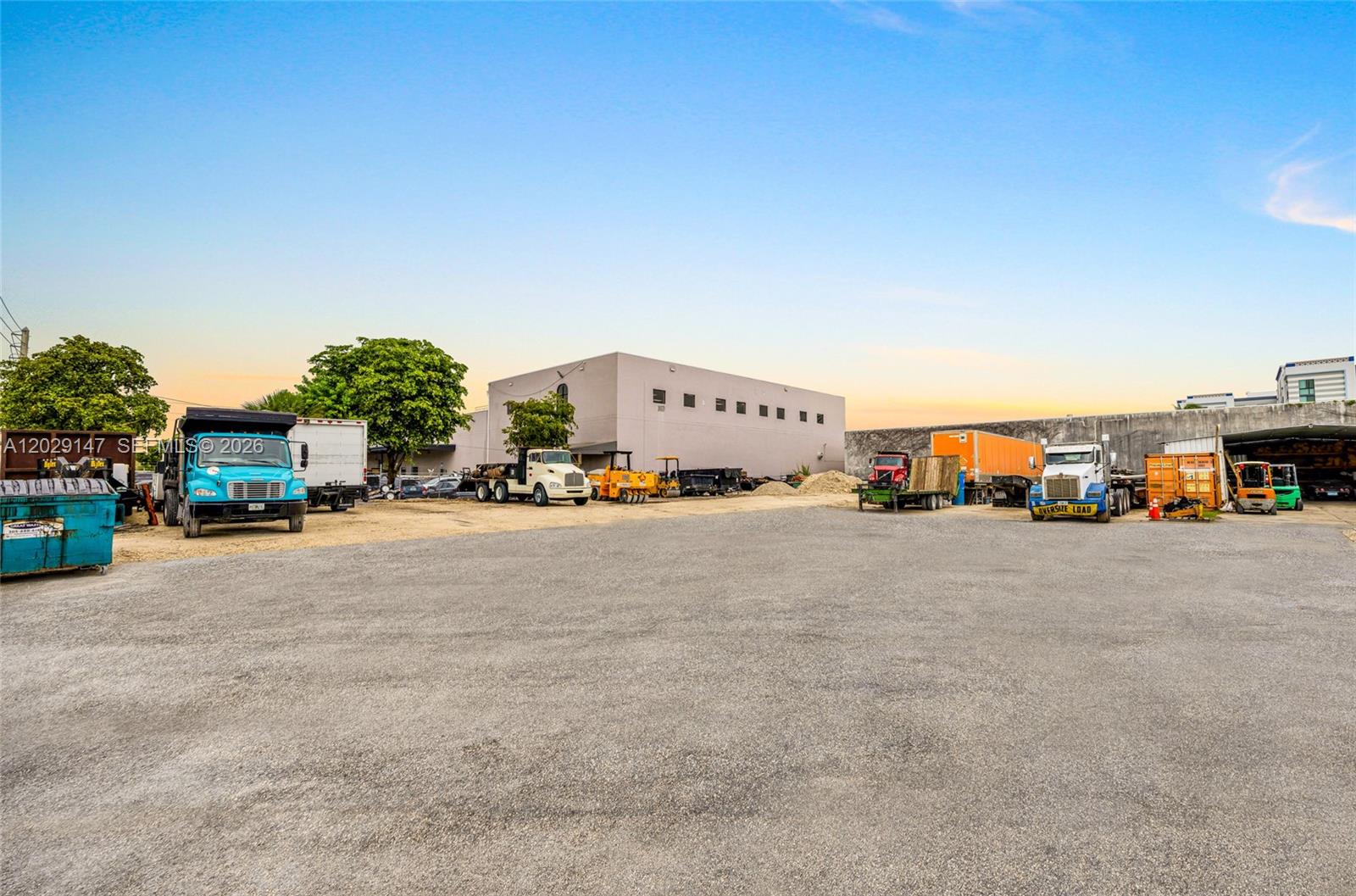 An outdoor industrial lot features several parked trucks, trailers, and heavy equipment — 14760 NW 24th Ct, Opa-Locka FL 33054, OPA-LOCKA, FL