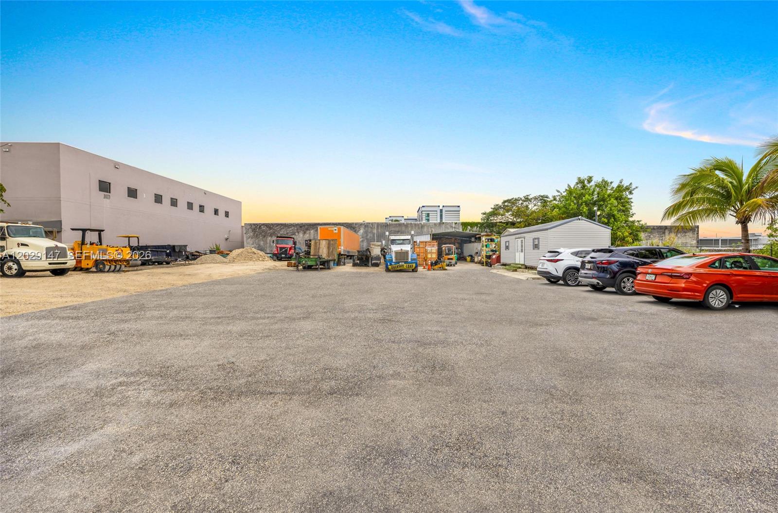 A large, paved industrial lot features parked vehicles, heavy equipment, and a small building — 14760 NW 24th Ct, Opa-Locka FL 33054, OPA-LOCKA, FL