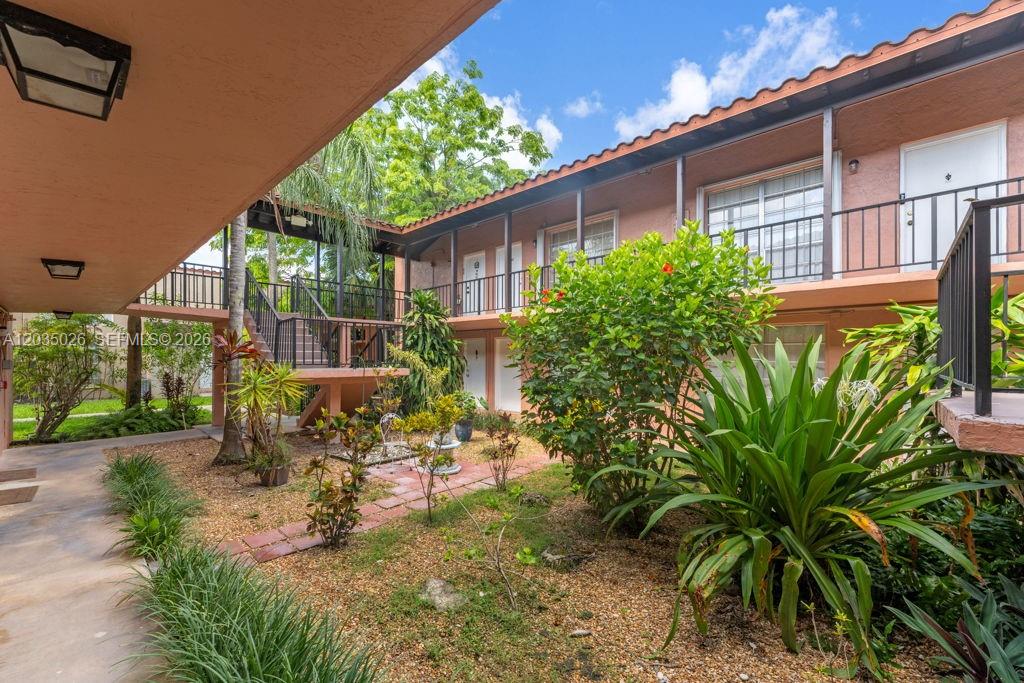 An exterior view of a two-story apartment complex with a central landscaped courtyard — 10832 N Kendall Dr # U1, Miami FL 33176, MIAMI, FL