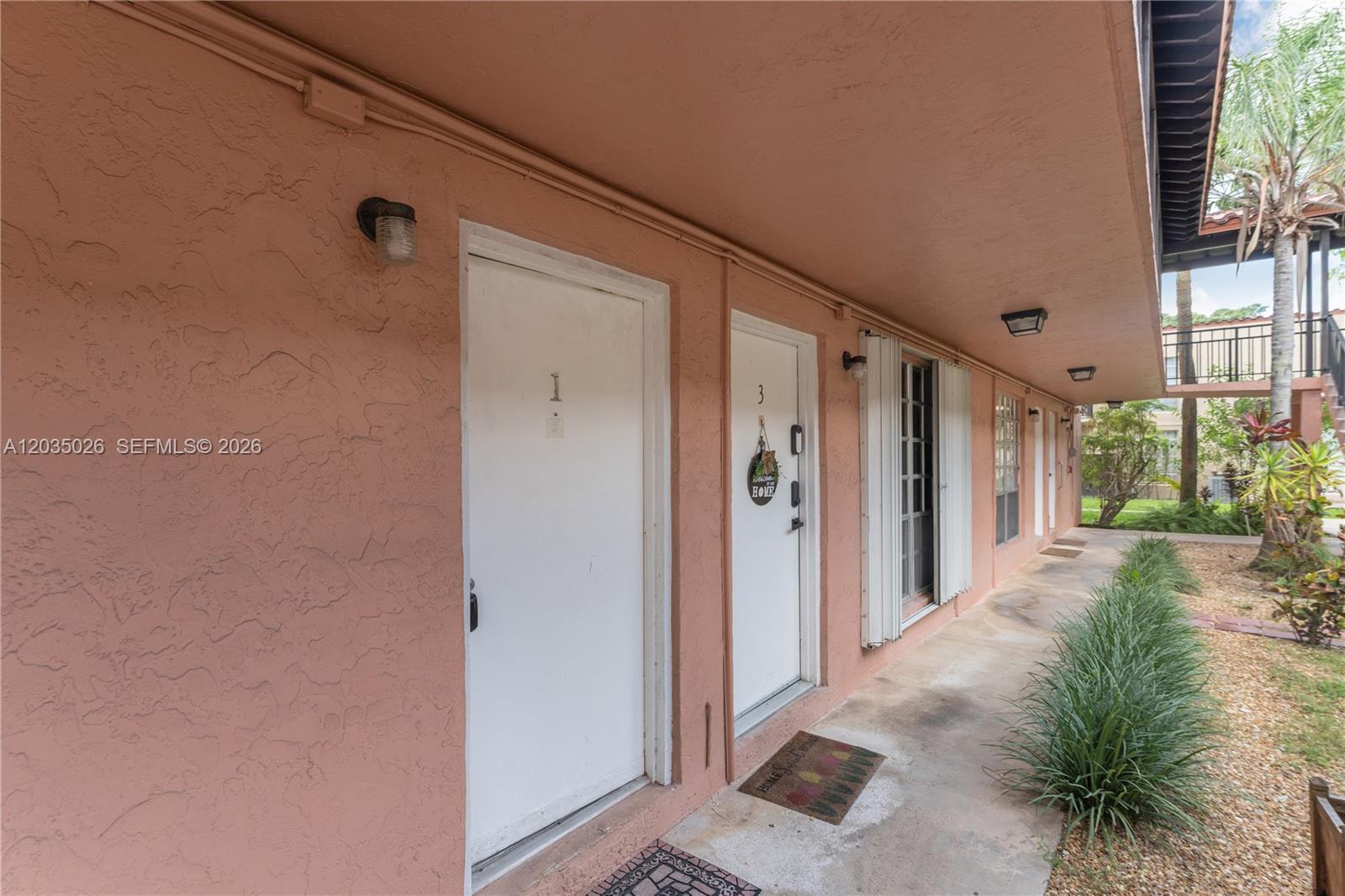 An exterior view shows a peach-colored building with two white doors numbered one and three — 10832 N Kendall Dr # U1, Miami FL 33176, MIAMI, FL