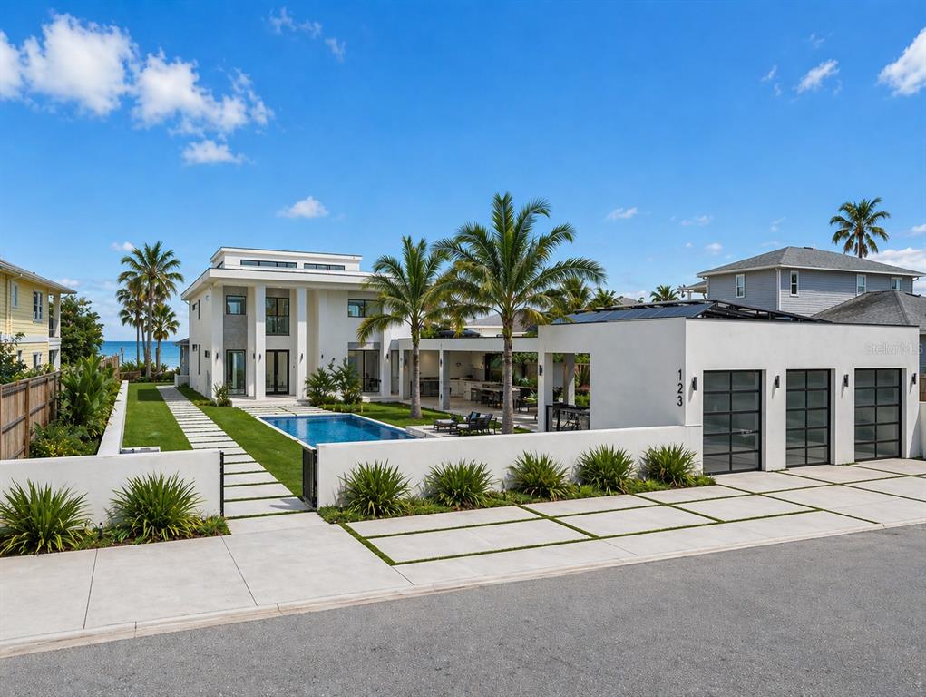 A modern white two-story house features a swimming pool, palm trees, and a three-car garage — 1817 BEACH DRIVE SE, ST PETERSBURG, FL