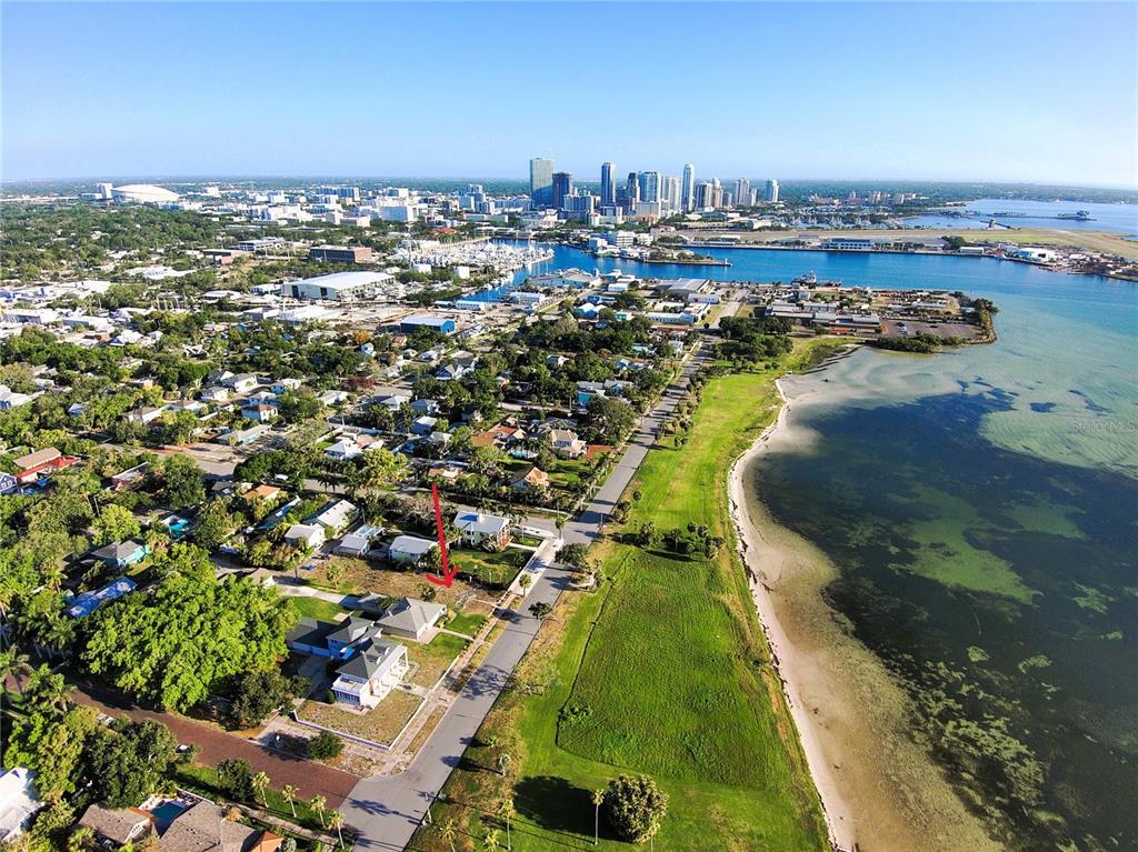 An aerial view shows a residential lot with a red arrow near a coastal waterfront — 1817 BEACH DRIVE SE, ST PETERSBURG, FL