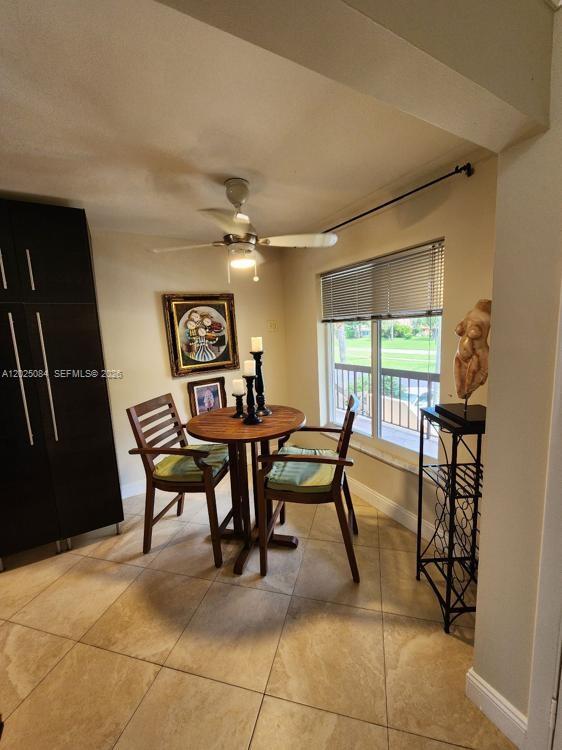 A dining area features a round wooden table, two chairs, tile flooring, and a ceiling fan — 5590 Via Delray # B, Delray Beach FL 33484, DELRAY BEACH, FL