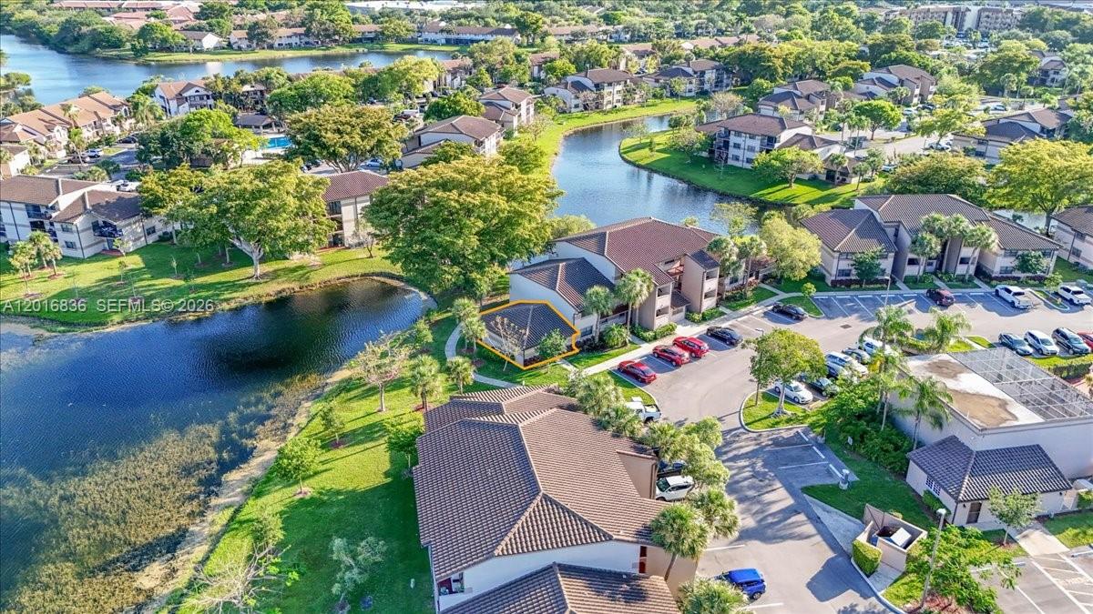 An aerial view shows a multi-story residential complex surrounded by a lake and landscaping — 9860 Nob Hill Ln # 9860, Sunrise FL 33351, SUNRISE, FL