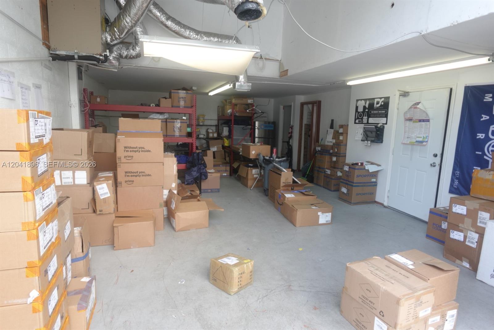 A storage room filled with numerous cardboard boxes, metal shelving units, and exposed ceiling ductwork — 12135 SW 131st Ave, Miami FL 33186, MIAMI, FL