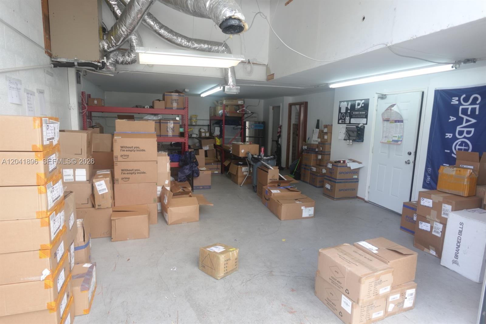 A cluttered storage room or warehouse space filled with numerous cardboard shipping boxes — 12135 SW 131st Ave, Miami FL 33186, MIAMI, FL