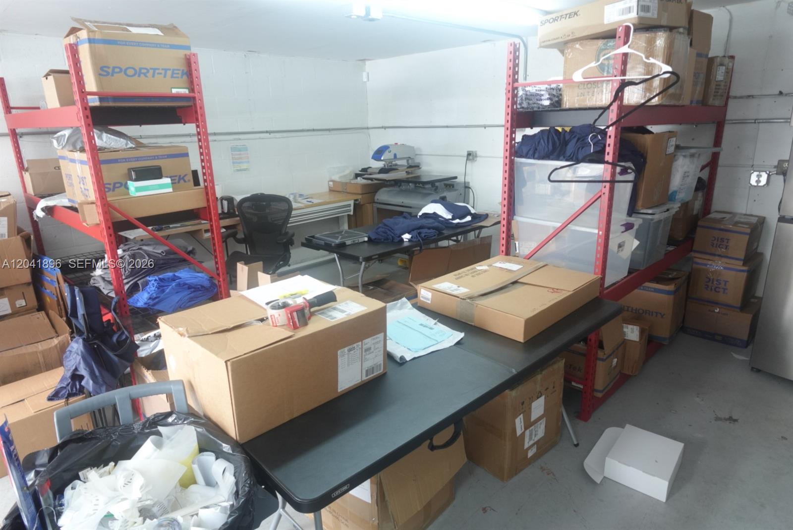A storage room features metal shelving units, work tables, and various cardboard shipping boxes — 12135 SW 131st Ave, Miami FL 33186, MIAMI, FL