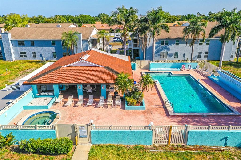 An aerial view of a community pool area with a hot tub and covered patio — 3784 59TH AVENUE W UNIT 3784, BRADENTON, FL