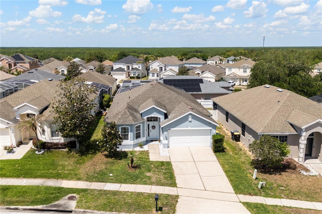 An aerial view shows a light blue single-story suburban house with a two-car garage — 333 HIGHER COMBE DRIVE, DAVENPORT, FL