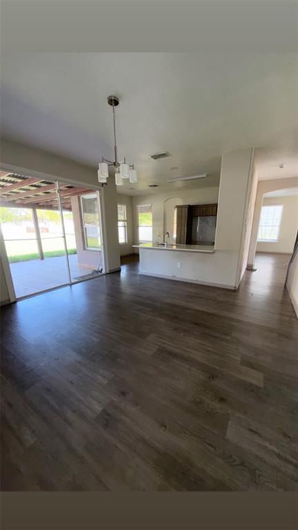 An open-concept dining area with wood-look flooring, a chandelier, and a view of the patio — 14114 ABACO ISLE DRIVE, ORLANDO, FL