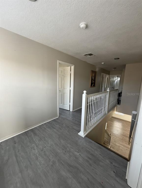 A second-floor hallway features gray wood-look flooring, white railings, and several interior doors — 14114 ABACO ISLE DRIVE, ORLANDO, FL