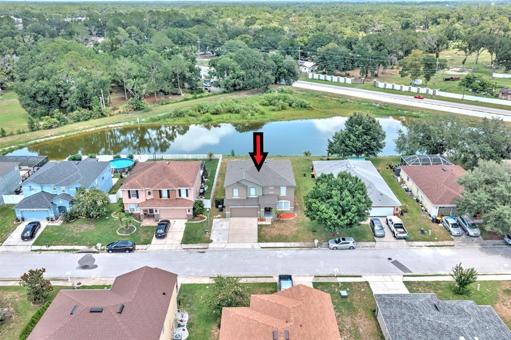 An aerial view shows a two-story suburban house with a gray roof and driveway — 7508 HUNTERS GREENE CIRCLE, LAKELAND, FL