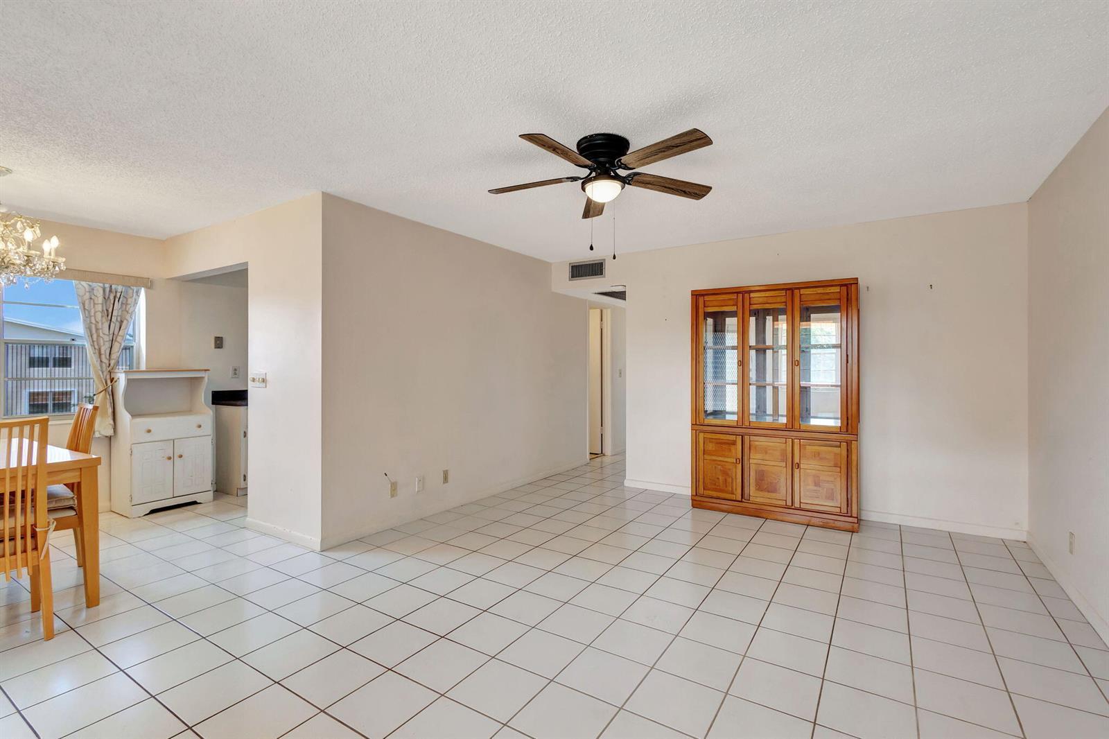 A dining area with white tile floors, a wooden hutch, and a ceiling fan — 332 Sheffield N, West Palm Beach FL 33417, WEST PALM BEACH, FL