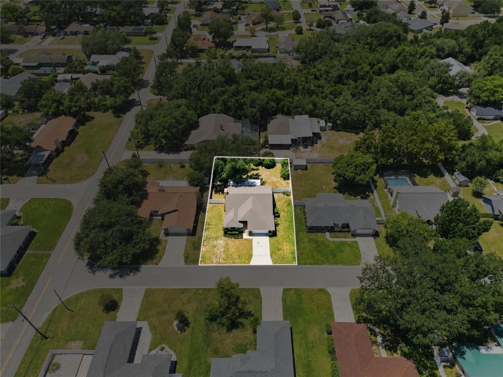 An aerial view shows a single-story house with a white outline on a residential lot — 1202 VALENCIA LANE, AUBURNDALE, FL