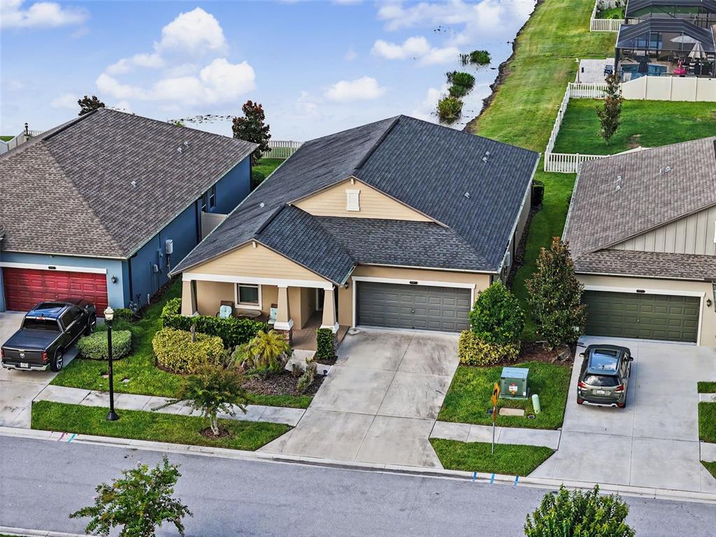 An aerial view shows a tan suburban house with a dark roof and a two-car garage — 9189 SHADYSIDE LANE, LAND O LAKES, FL