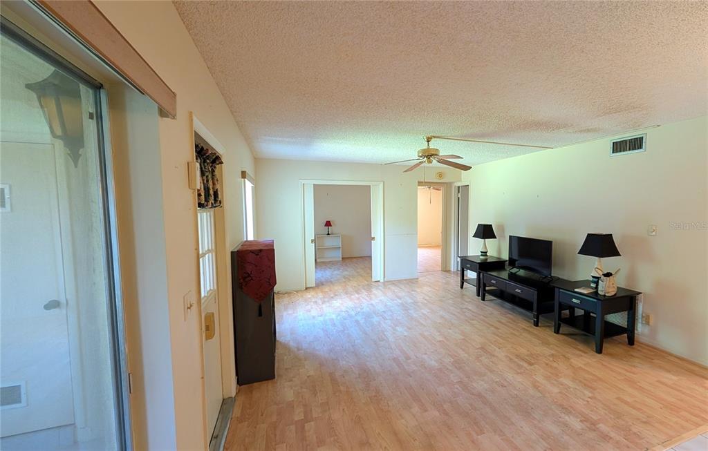 A living room features light wood-look flooring, white walls, and a ceiling fan — 328 PINE RIDGE CIRCLE UNIT C1, GREENACRES, FL
