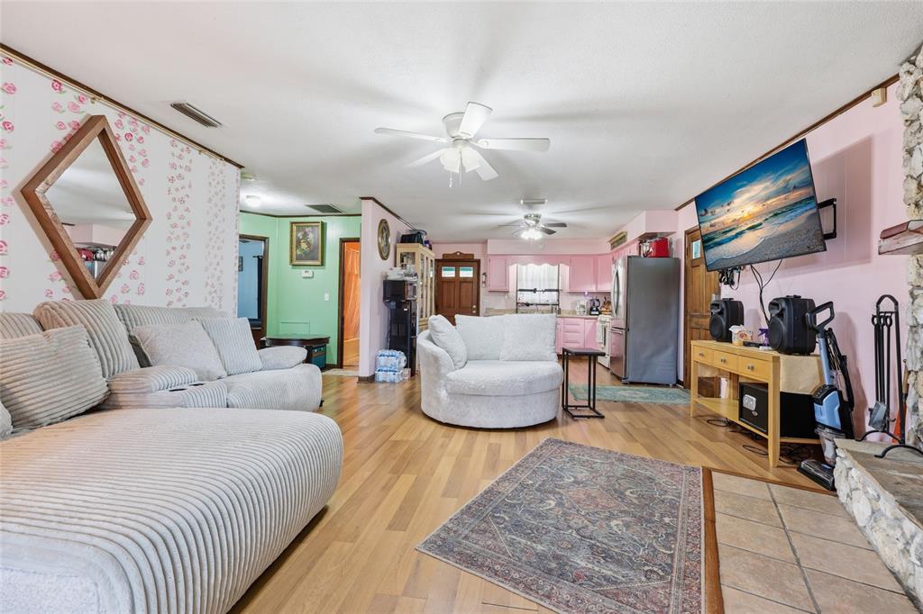 A living room with light wood floors, pink walls, a fireplace, and a white sofa — 8399 SE 68TH COURT, TRENTON, FL