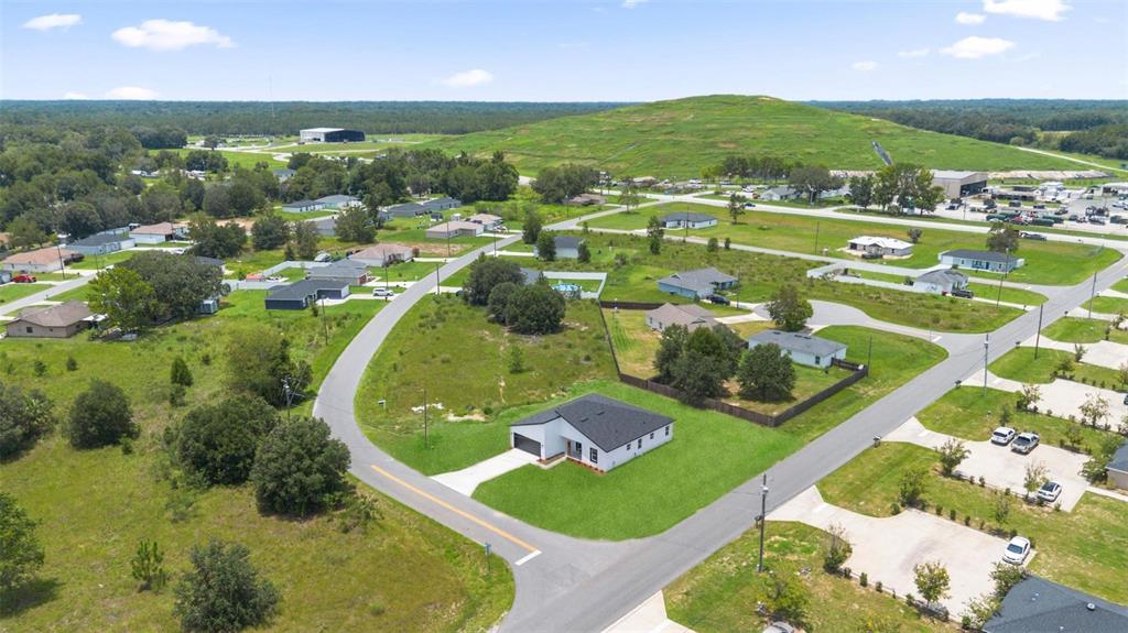 An aerial view shows a modern white house with a dark roof in a neighborhood — 55 LAUREL COURSE, OCALA, FL