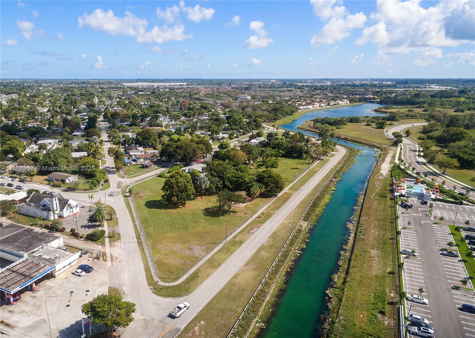 An aerial view shows a canal running alongside a road, parking lot, and residential neighborhood — 272 Street, Naranja FL 33032, NARANJA, FL