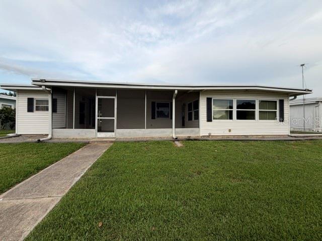 A single-story house with a screened-in front porch and a concrete walkway on a lawn — 1023 SOUTHLAND DRIVE, TAVARES, FL