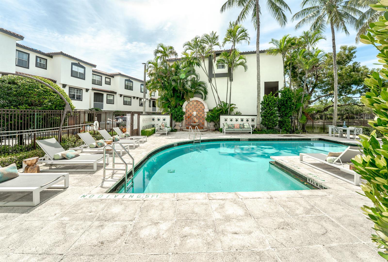 A swimming pool with lounge chairs and palm trees sits in front of a residential building — 20889 Saint Andrews Boulevard, Boca Raton FL 33433, BOCA RATON, FL