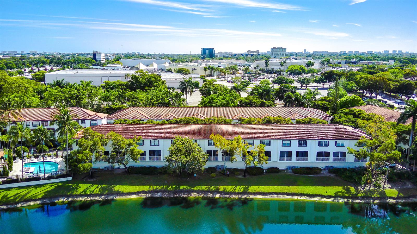 An aerial view of a multi-story apartment building with a red tile roof beside water — 20889 Saint Andrews Boulevard, Boca Raton FL 33433, BOCA RATON, FL