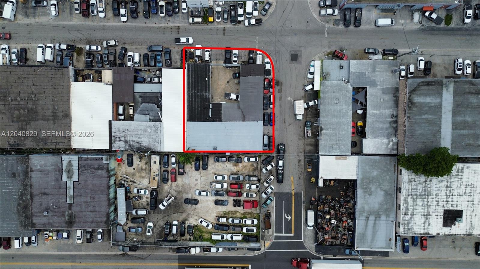 This aerial view shows a commercial building with a fenced parking lot and surrounding streets — 1025 E 45th St, Hialeah FL 33013, HIALEAH, FL