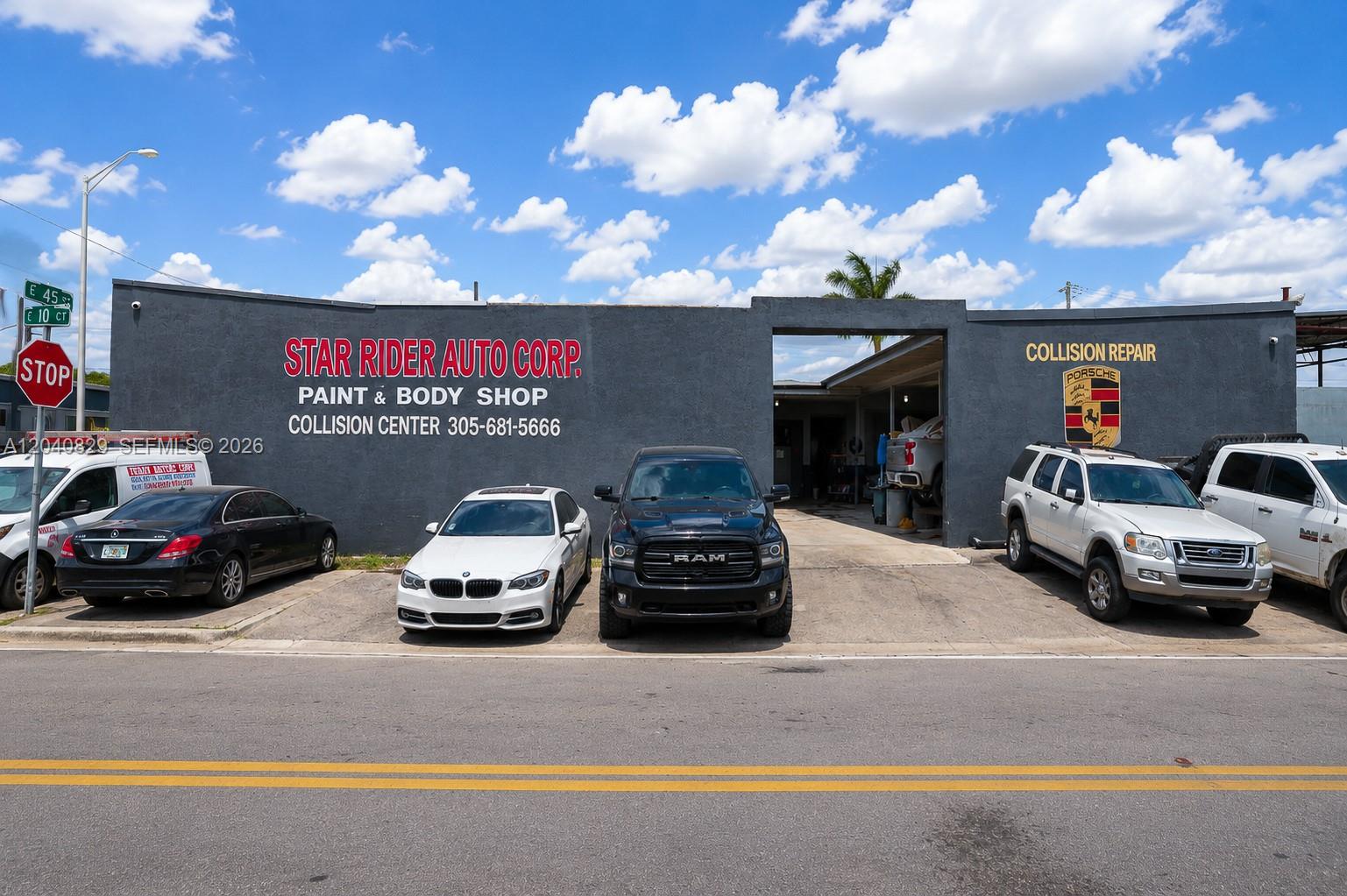 The exterior of an auto body shop features a grey facade with parked vehicles — 1025 E 45th St, Hialeah FL 33013, HIALEAH, FL