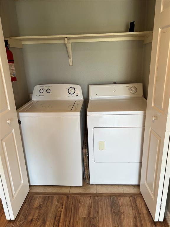 A laundry closet contains a white top-loading washing machine and a matching dryer — 3740 IDLEBROOK CIRCLE UNIT 202, CASSELBERRY, FL