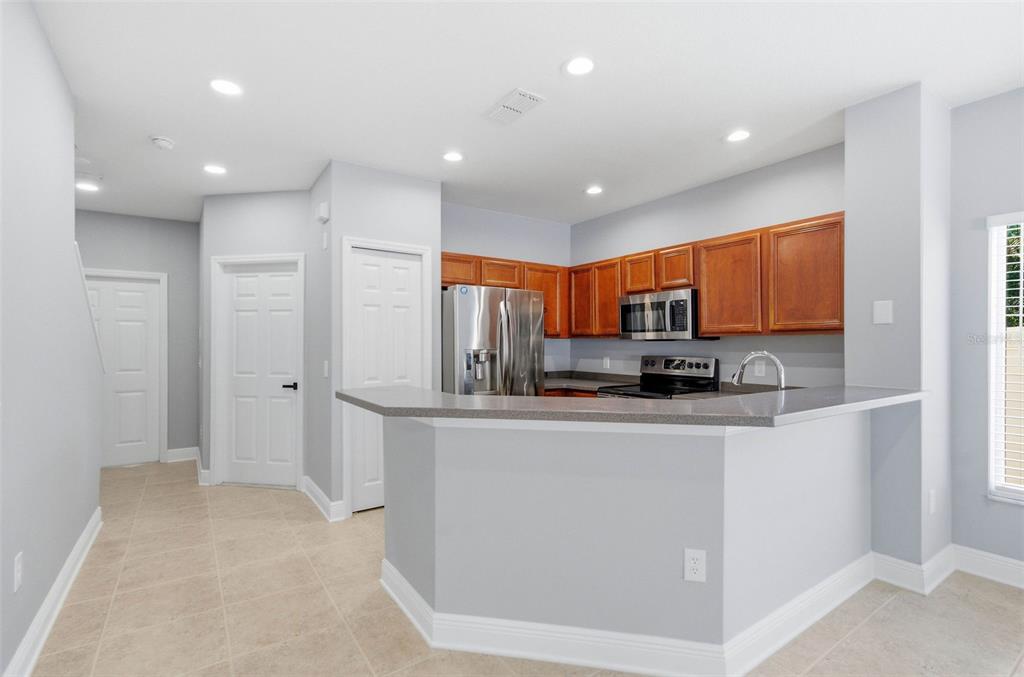 A kitchen with a breakfast bar, stainless steel appliances, and wood cabinets — 20402 NEEDLETREE DRIVE, TAMPA, FL
