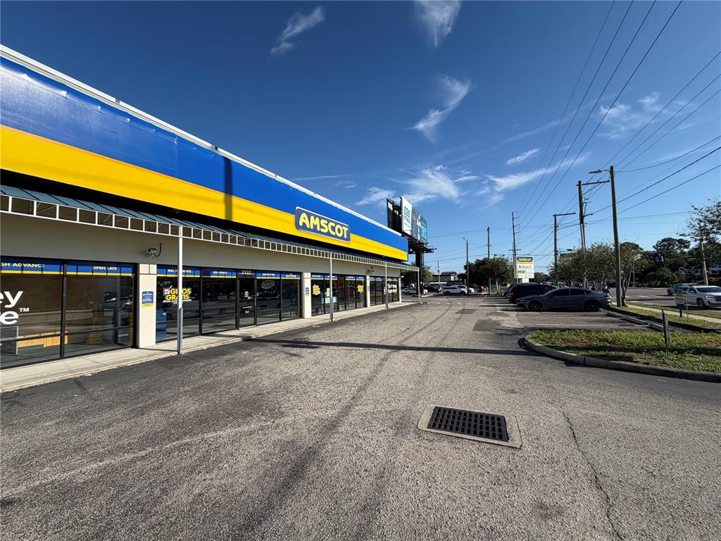 An exterior view of an Amscot storefront with a blue and yellow facade — 2910 N HIMES AVENUE UNIT 2922, TAMPA, FL