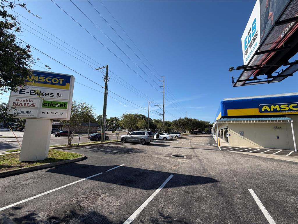 A parking lot sits in front of a commercial building with a large advertising billboard — 2910 N HIMES AVENUE UNIT 2922, TAMPA, FL