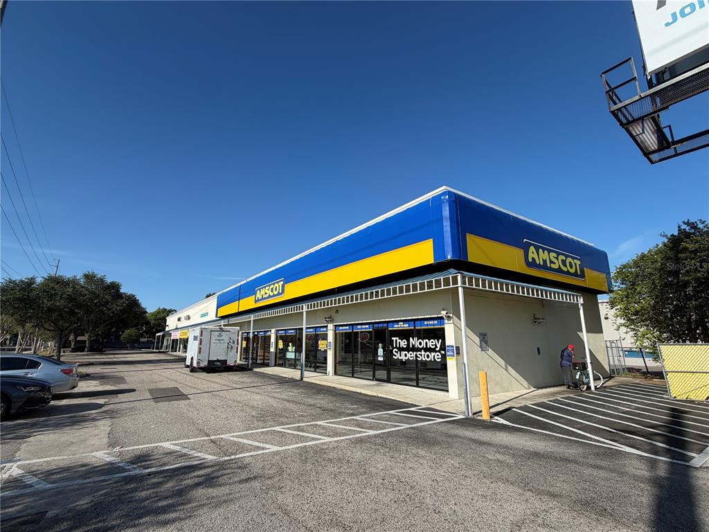 An exterior view of an Amscot storefront with a blue and yellow awning — 2910 N HIMES AVENUE UNIT 2922, TAMPA, FL