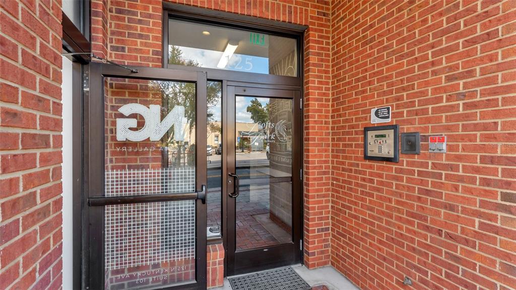 A glass-paned entrance door with a brick exterior and an intercom system — 125 N KENTUCKY AVENUE UNIT 505, LAKELAND, FL