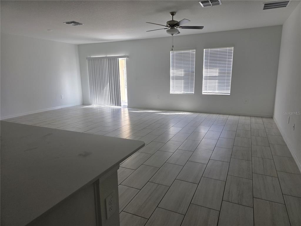 An empty bedroom with gray carpet, white walls, and two windows with closed blinds — 12588 TIMBER MOSS LANE, RIVERVIEW, FL